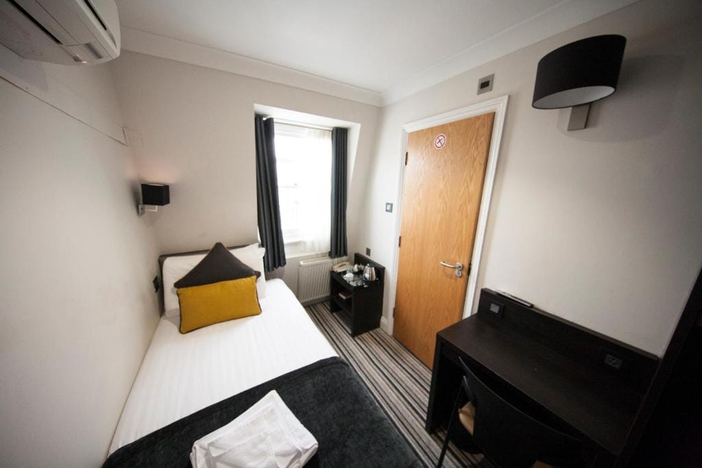 A single room with one single bed, air conditioning and a writing desk