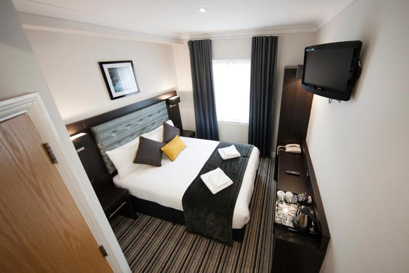 A double room with one double bed, wall-mounted television and a hospitality tray