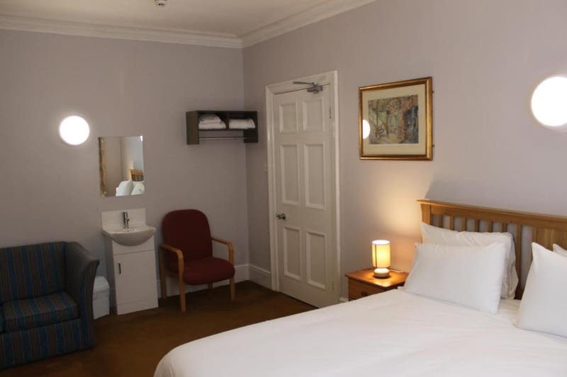 Deluxe double room with sofa and wash basin