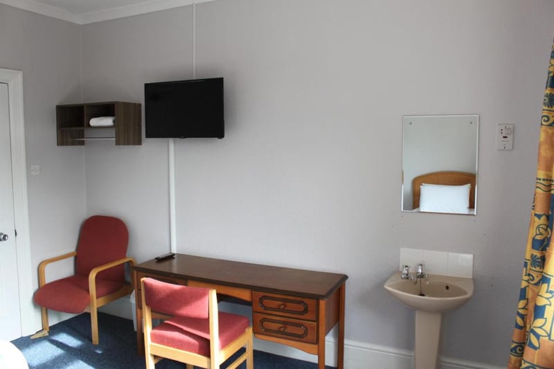 Desk, TV and wash basin in the twin room