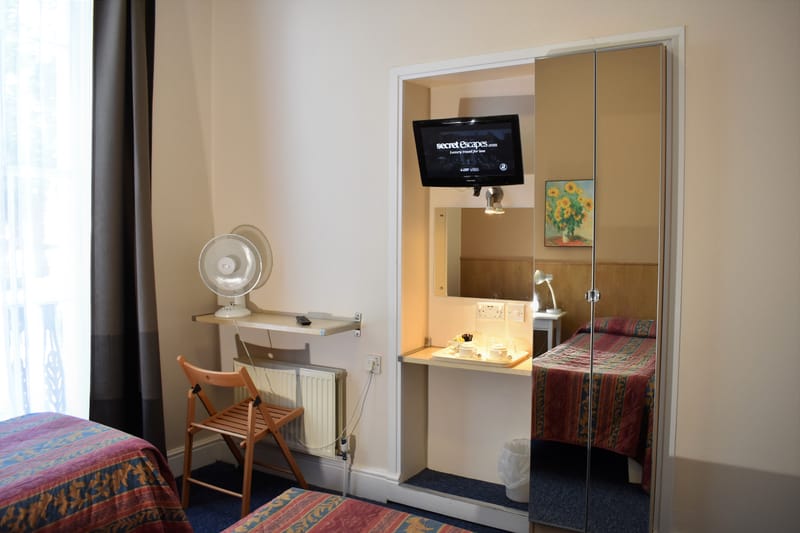 Twin room with its own bathroom — desk, mirror and television