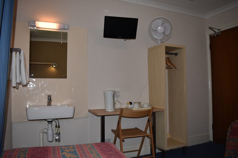 Twin room with shared bathroom — washbasin, desk and television