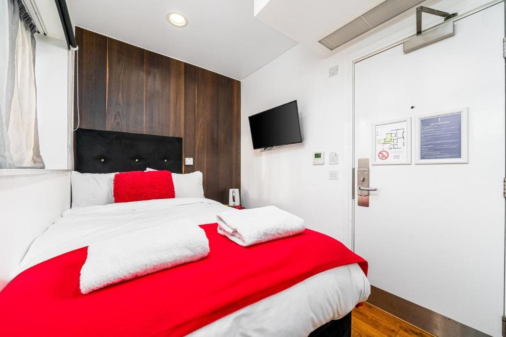 A Superior Double Room, with a double bed against walnut panelling