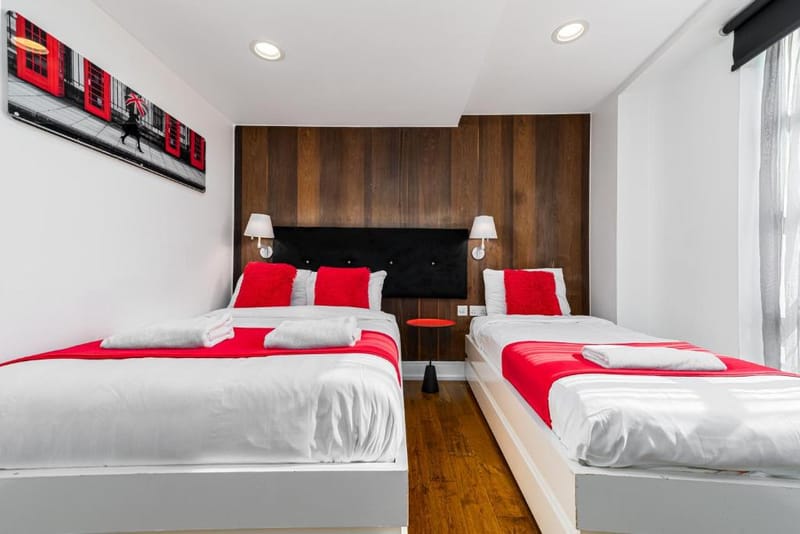 A Classic Triple Room's double and single beds under walnut panelling