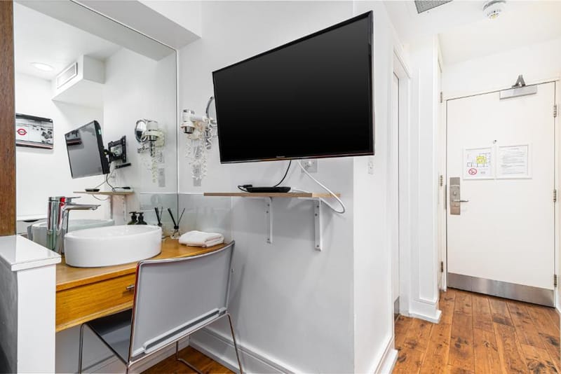 Wall-mounted television and washbasin in a Small Double Room
