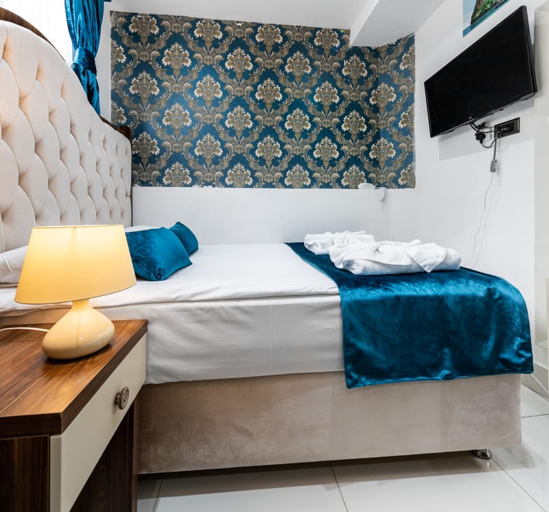 The double bed against the damask feature wall